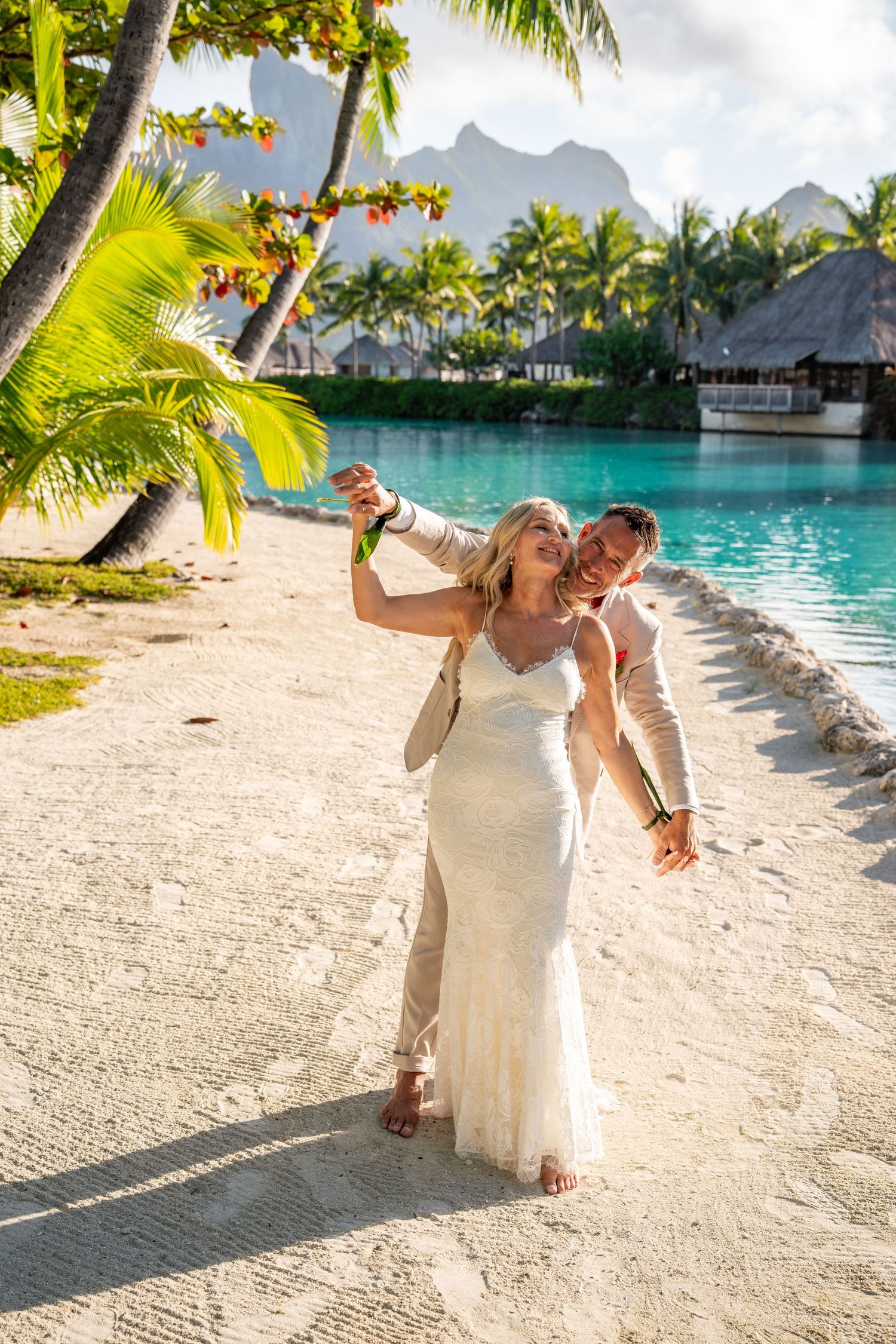 Newlywed couple celebrating on the beach during their Bora Bora destination wedding
