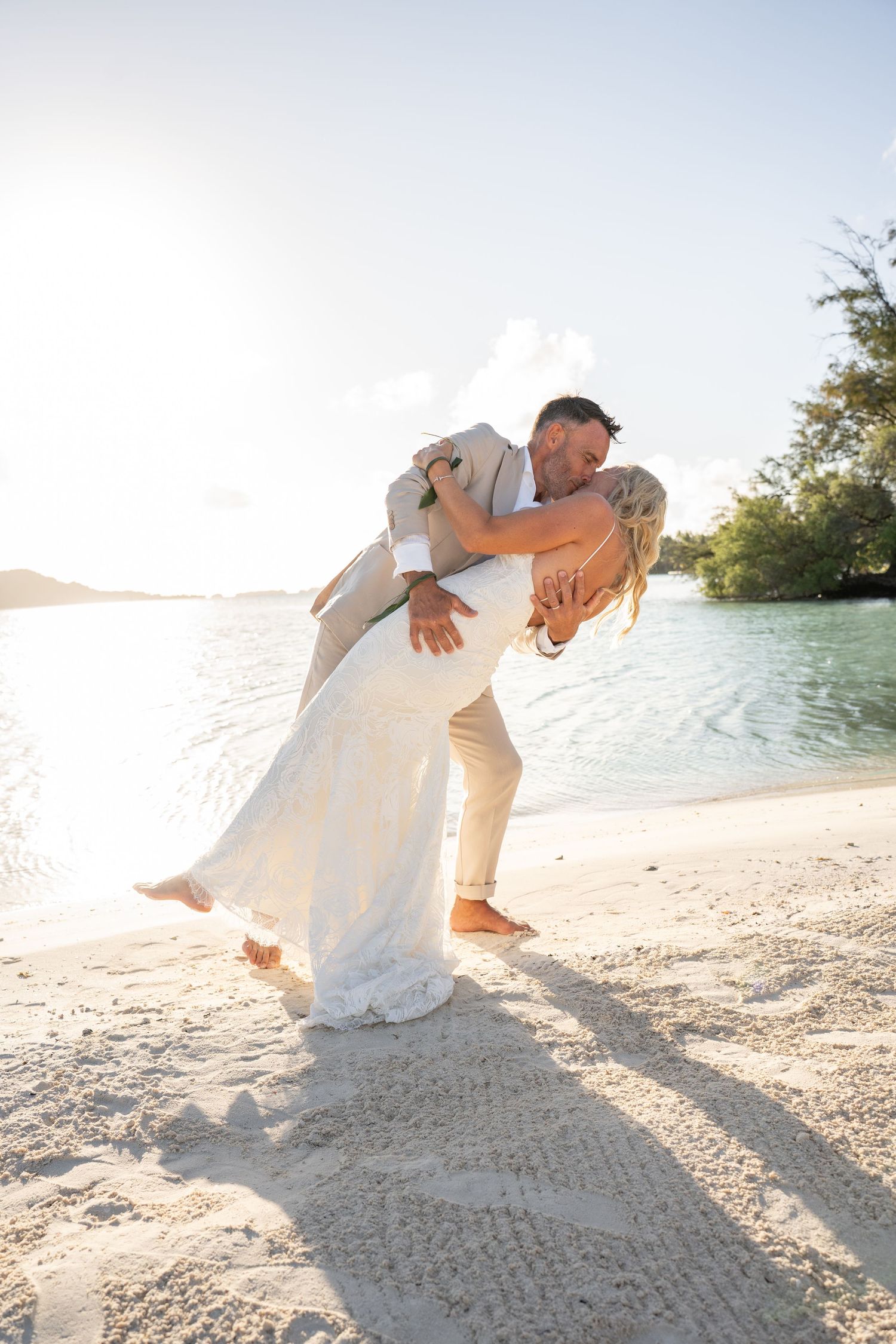 Groom lifting his bride during a romantic beach wedding photoshoot in Bora Bora