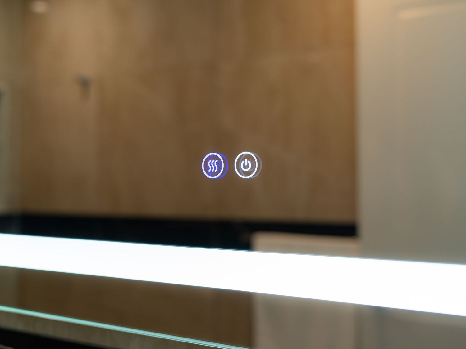 Illuminated bathroom mirror with touch control buttons, featuring power and demister icons on a sleek LED-lit surface.