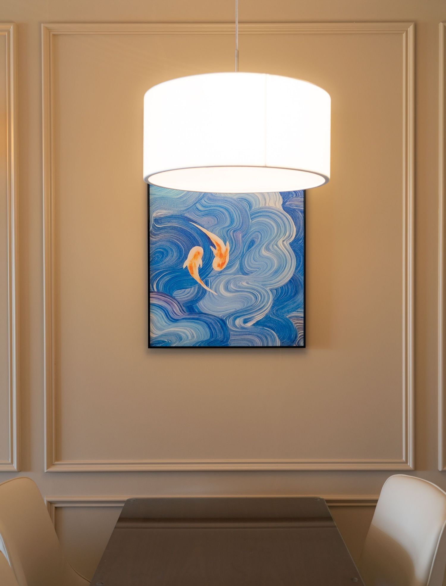 Elegant dining room featuring a white drum pendant light above a table with a vibrant blue koi fish painting on the wall.