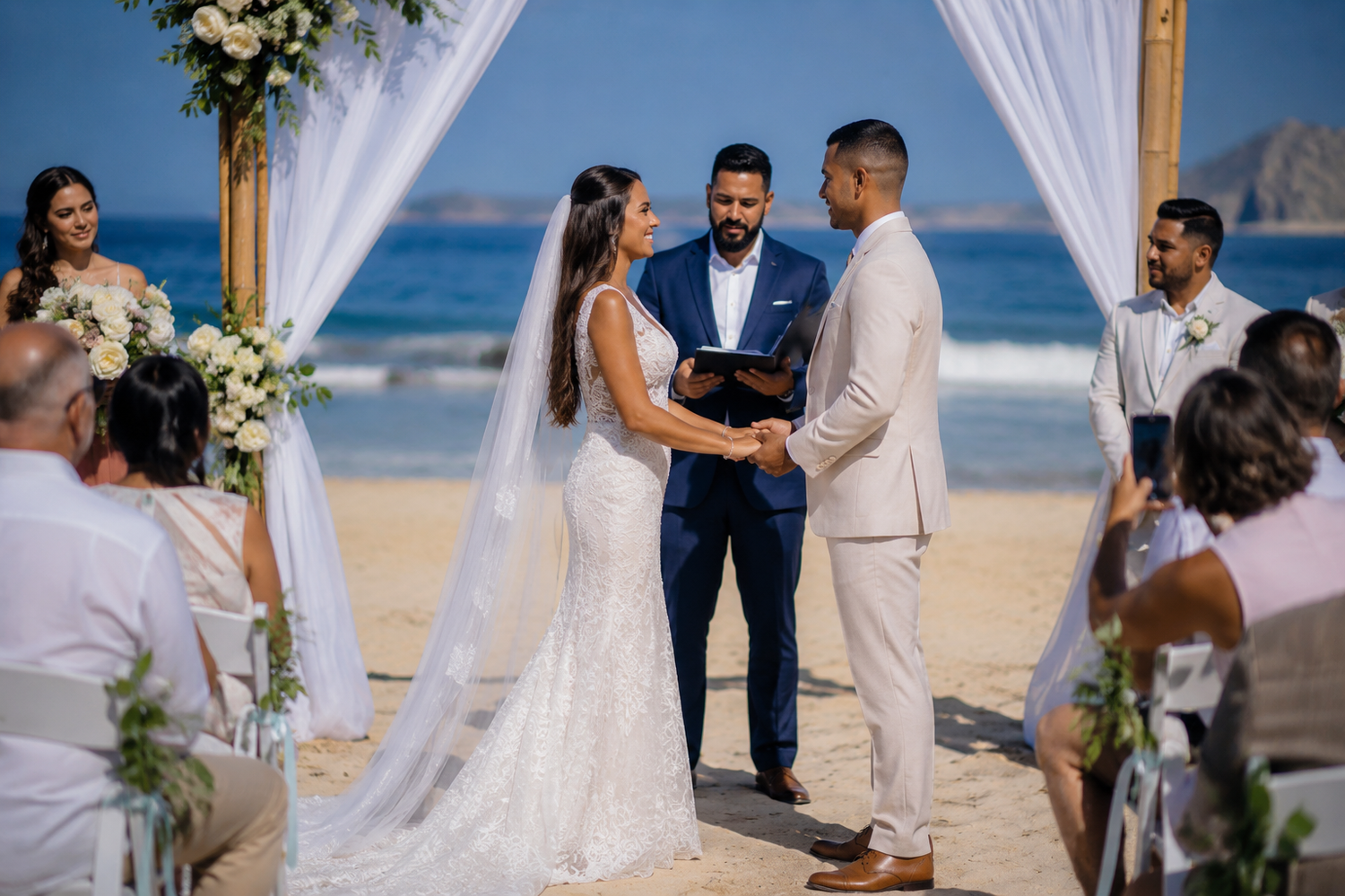 Beach wedding ceremony with bride and groom exchanging vows under a floral arch.