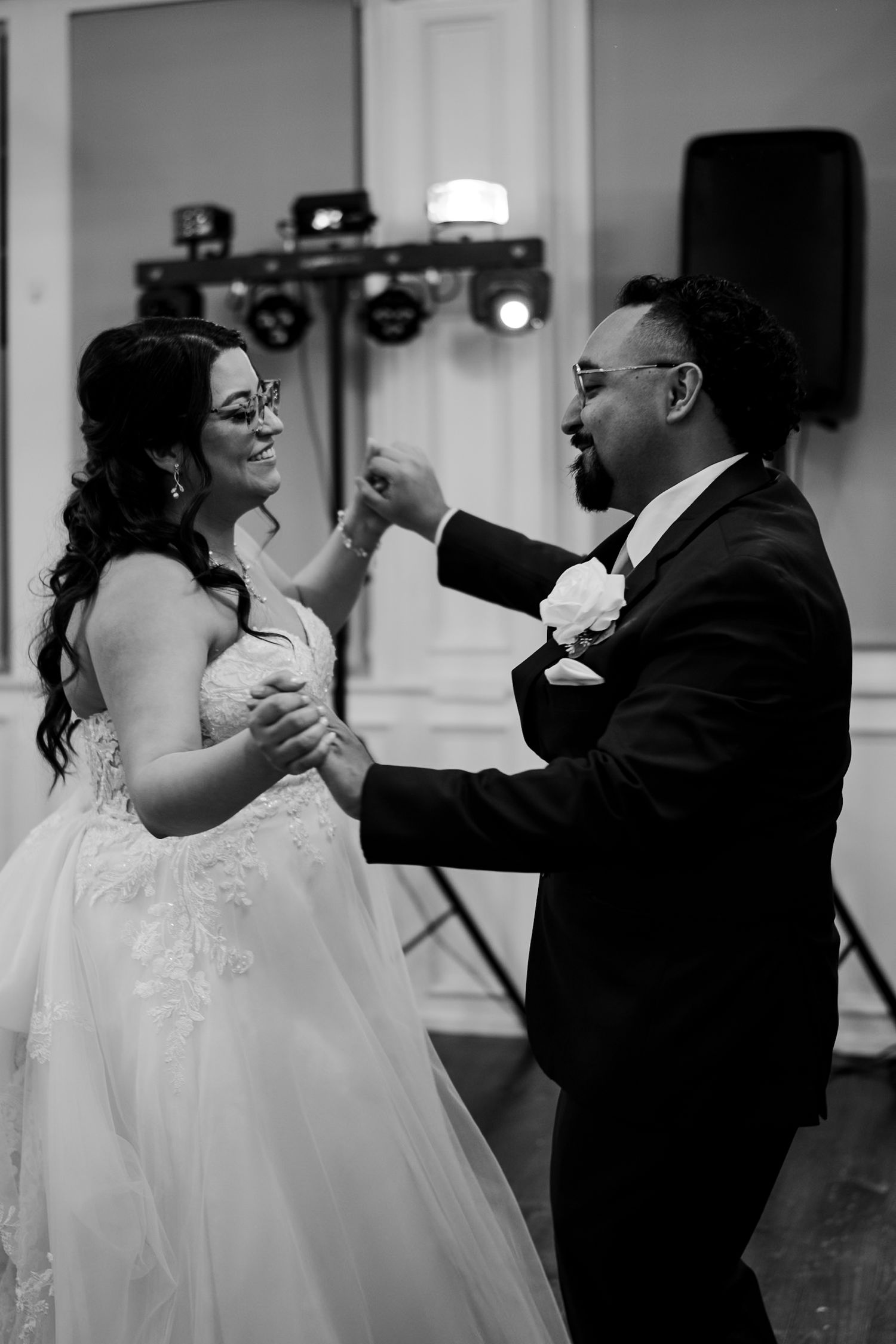Black and white photo of bride and groom sharing first dance at wedding reception.