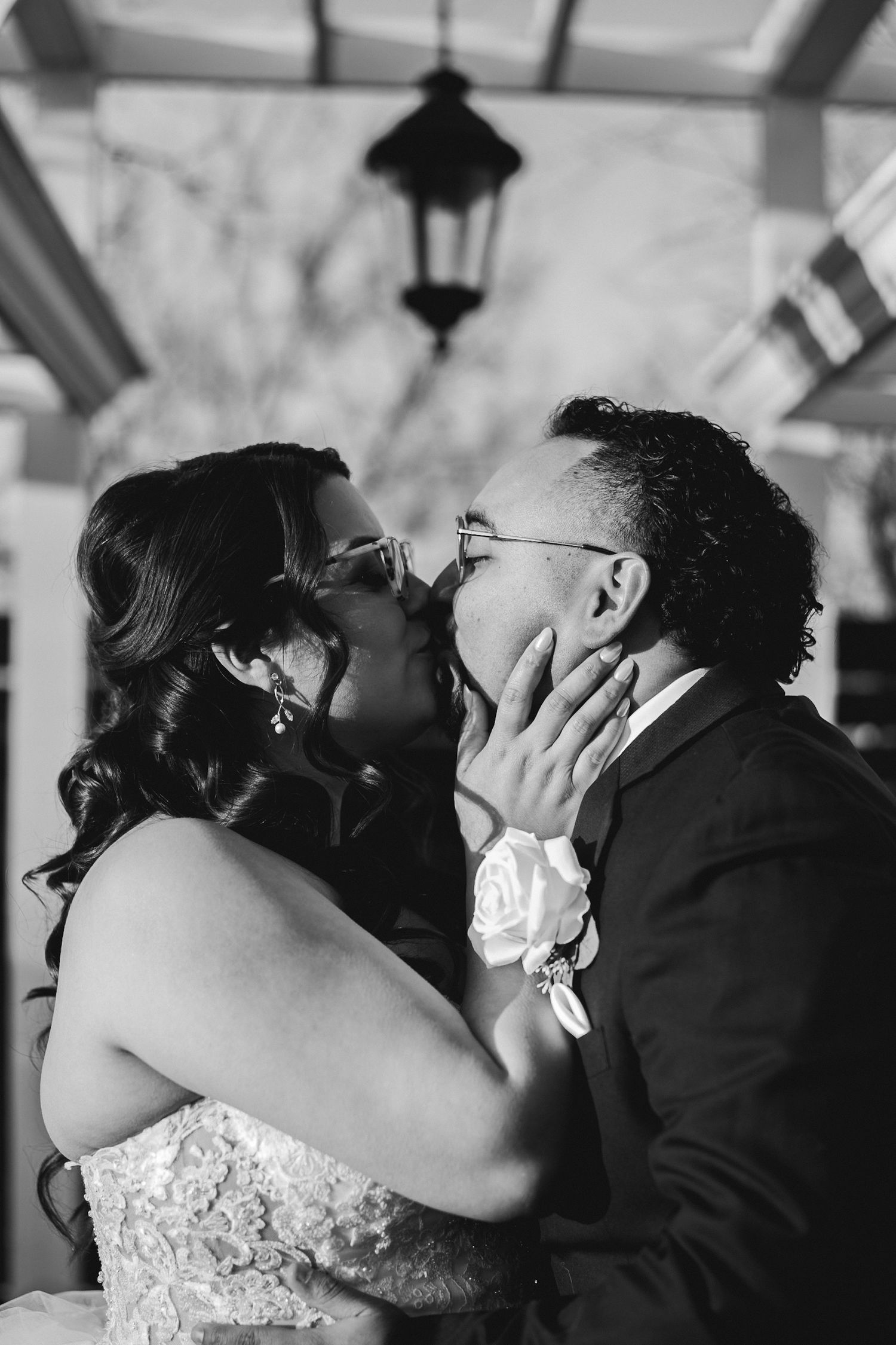 Black and white photo of bride and groom sharing a kiss at wedding.