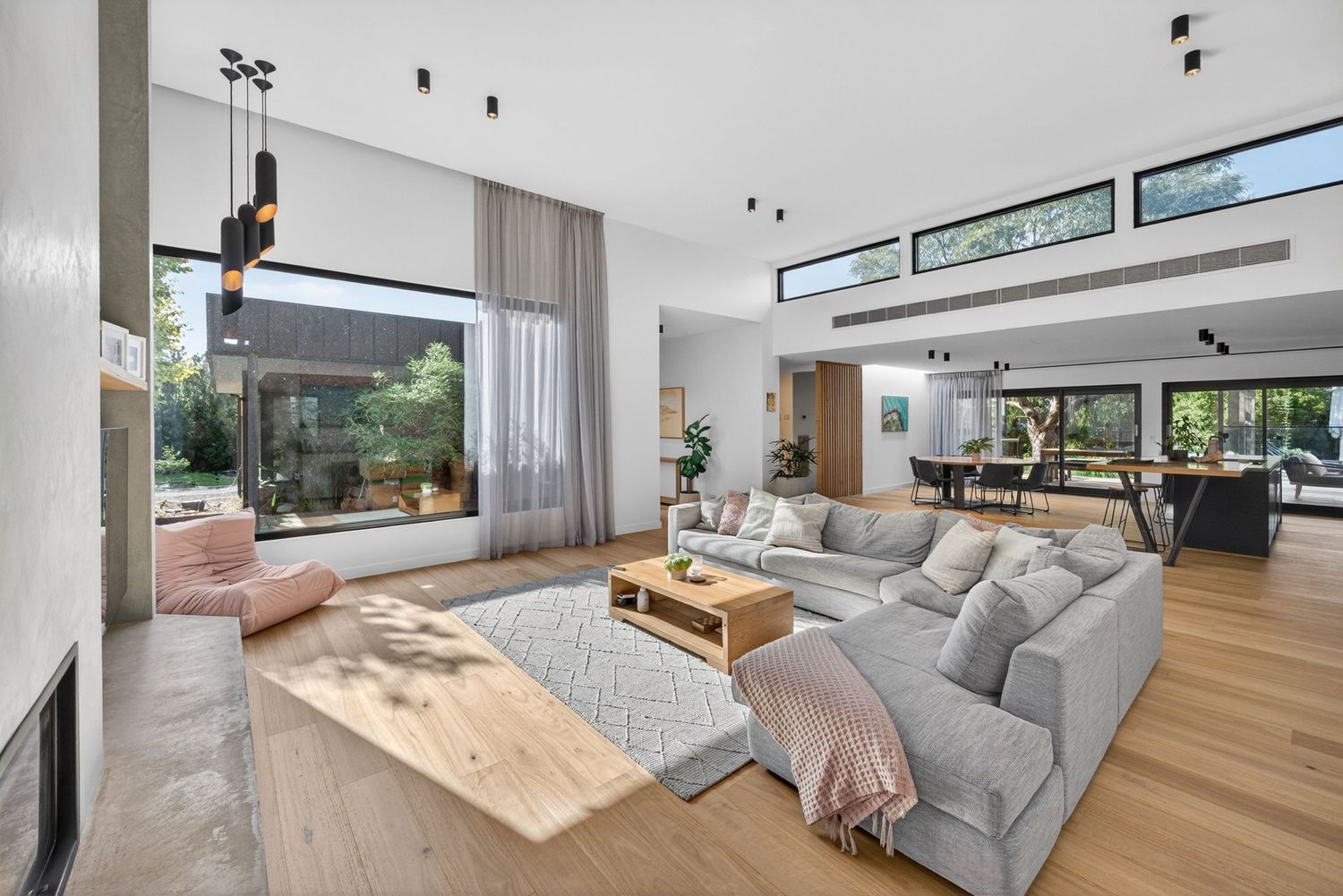 Lounge and dining wide shot showing open-plan living, natural light, and cohesive interior design flow between spaces.
