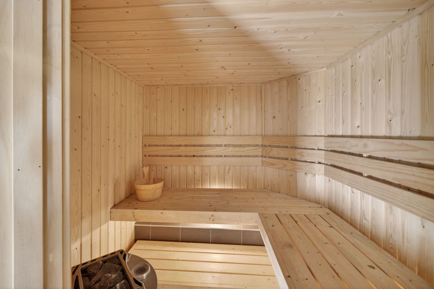 Shot of a sauna interior highlighting warm timber finishes, soft lighting, and a calm, spa-like wellness space.