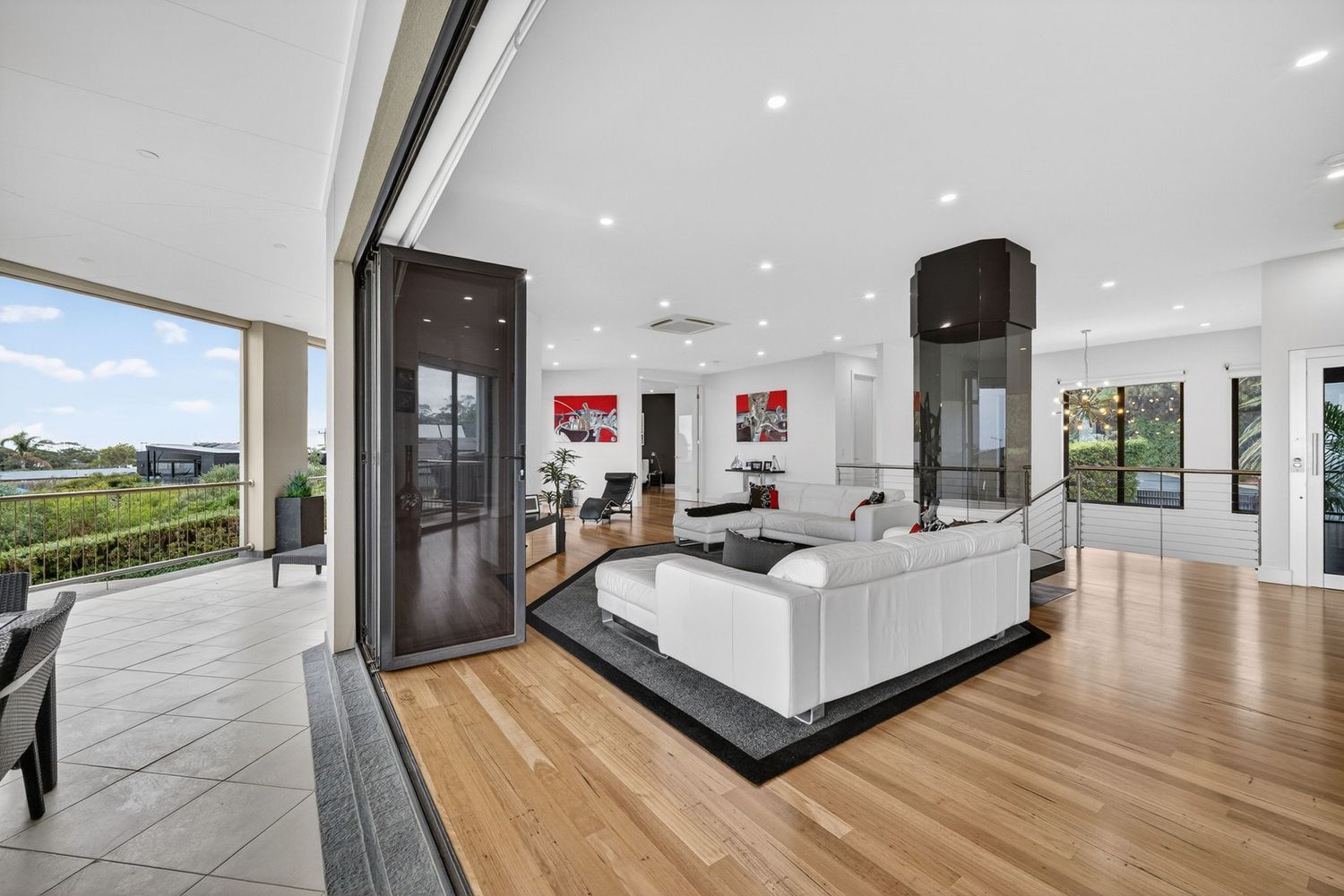 View from balcony dining area looking into the living space, showcasing indoor-outdoor flow, open-plan design, and natural light
