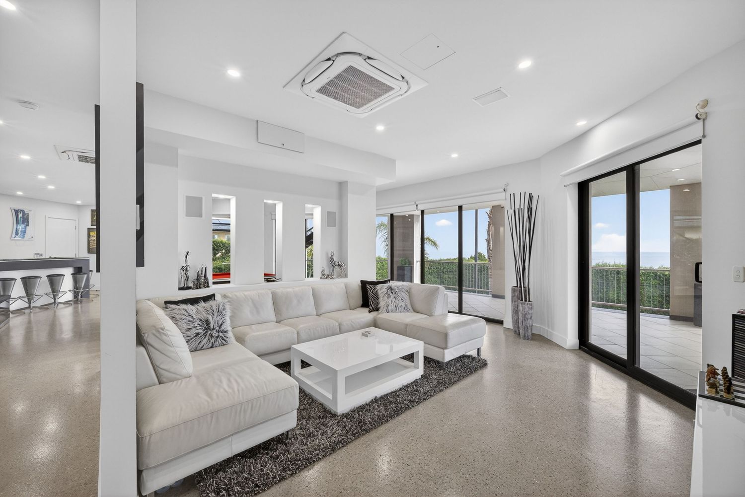 Second living area featuring relaxed lounge space, comfortable seating, and cohesive interior design with natural light and modern styling