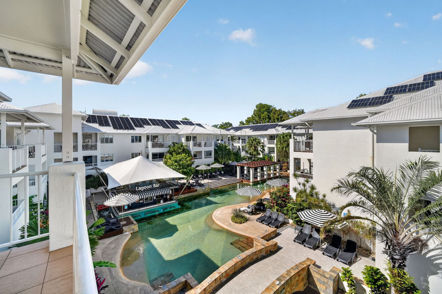 View of lagoon pool from holiday apartment balcony, showcasing elevated perspective,resort-style water views, and relaxed coastal atmosphere