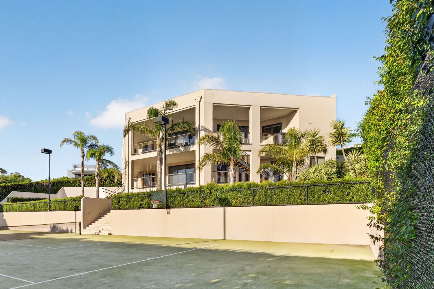 Exterior shot of a prestige home in Mount Eliza captured from the tennis court, highlighting expansive landscaping, architectural design
