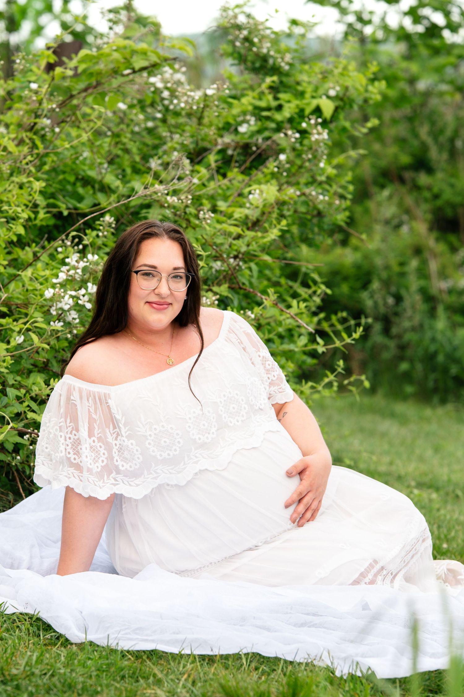pregnant mother in white flowy dress in field of green