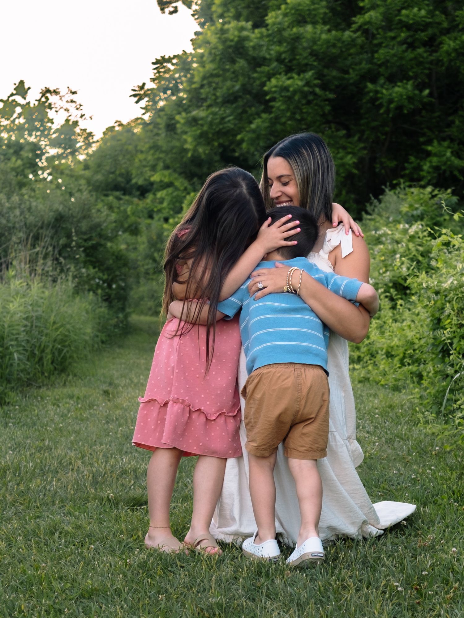 Mother holding her kids lovingly and laughing at middle creek.