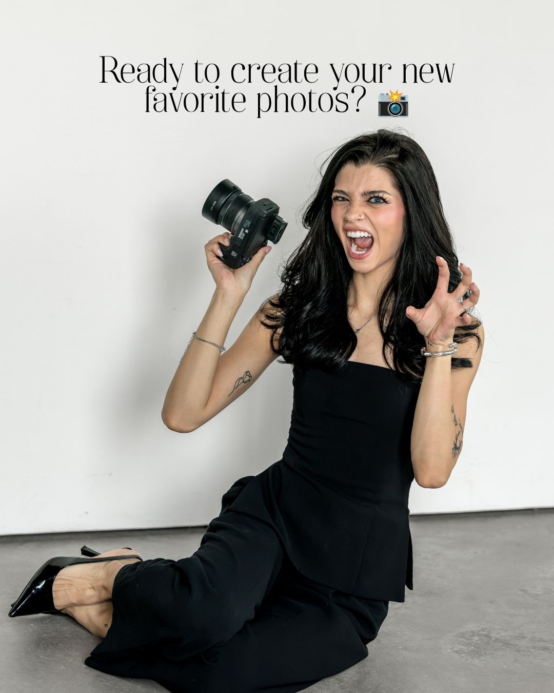 A woman in a black dress sits on the floor holding a camera, laughing, with text reading Ready to create your new favorite photos.