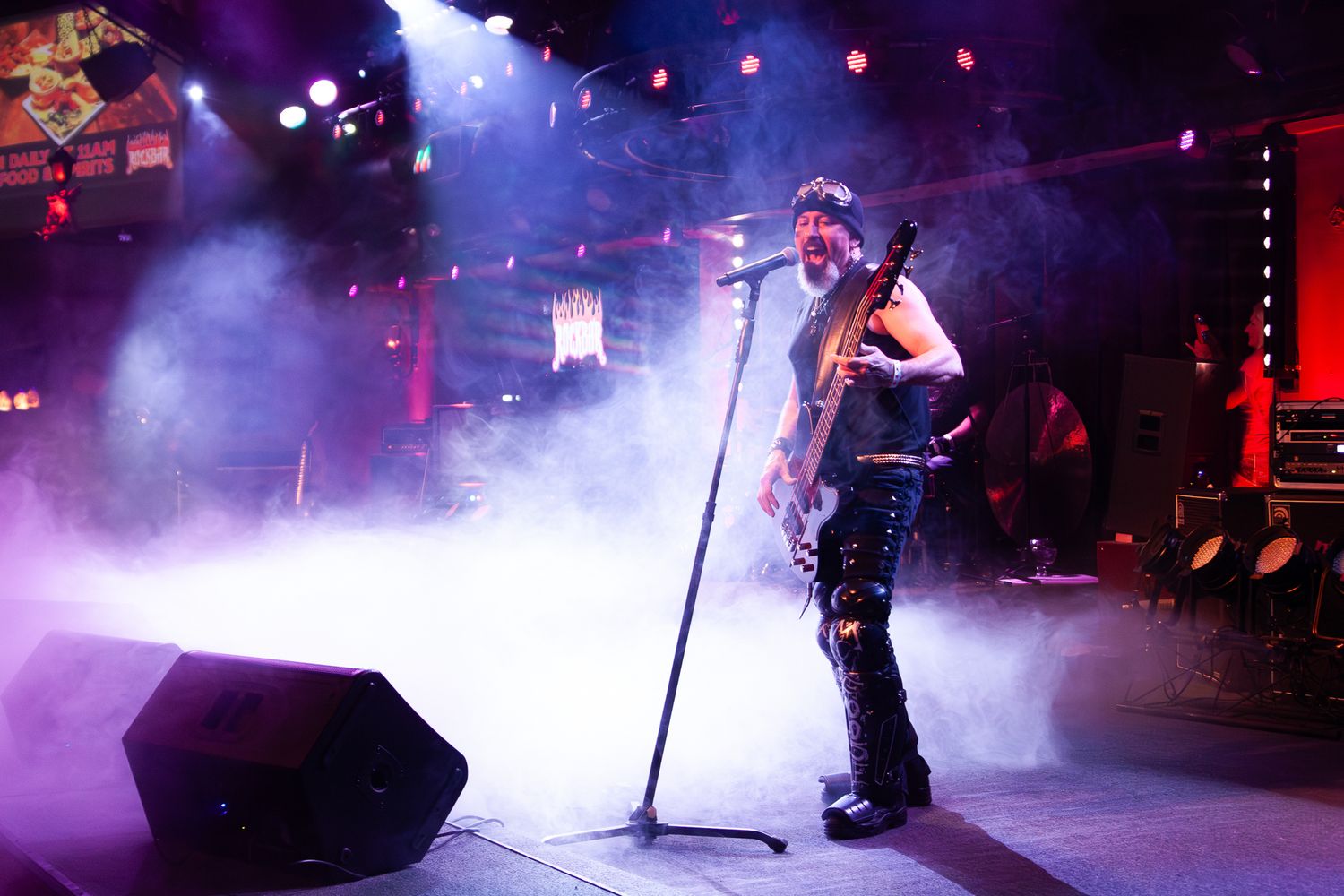 A guitar player on stage with fog and dramatic lighting