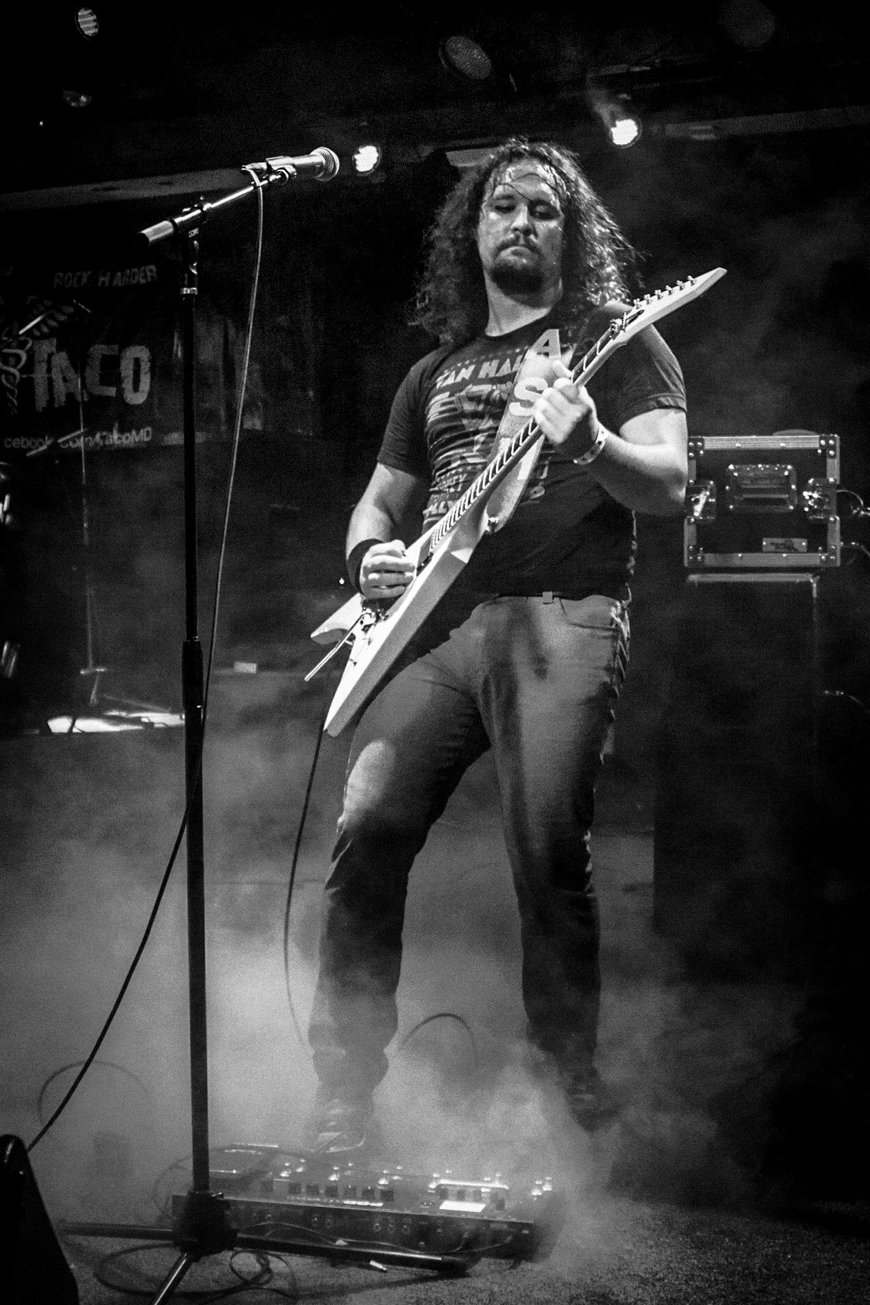 A black and white photo of a rock musician performing on stage