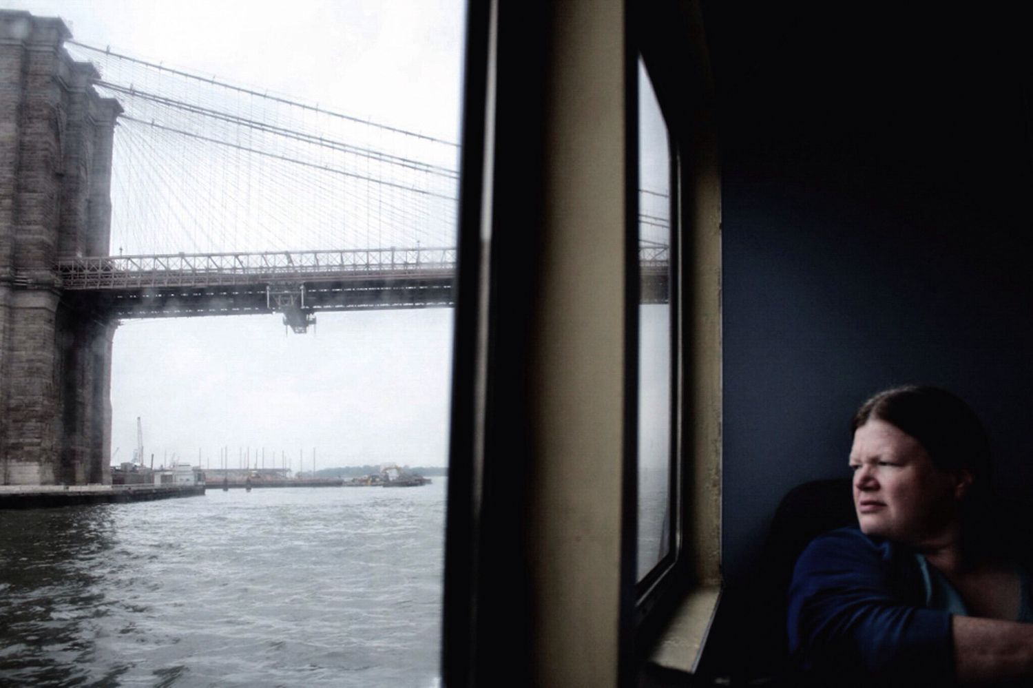 A woman looks out the window of a ferry in Brooklyn New York