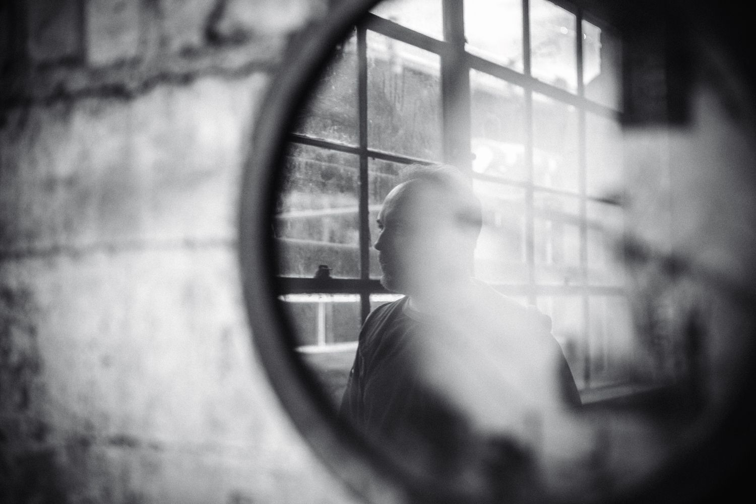 A black and white portrait of the reflection of a man