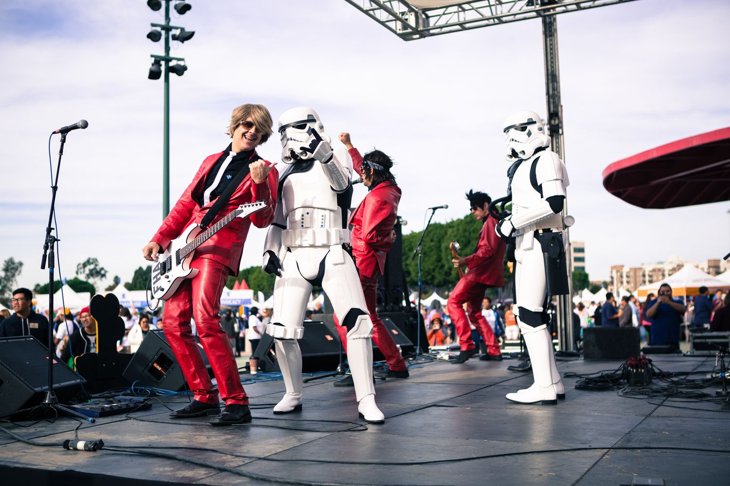 Stormtroopers join a rock band on stage at an event