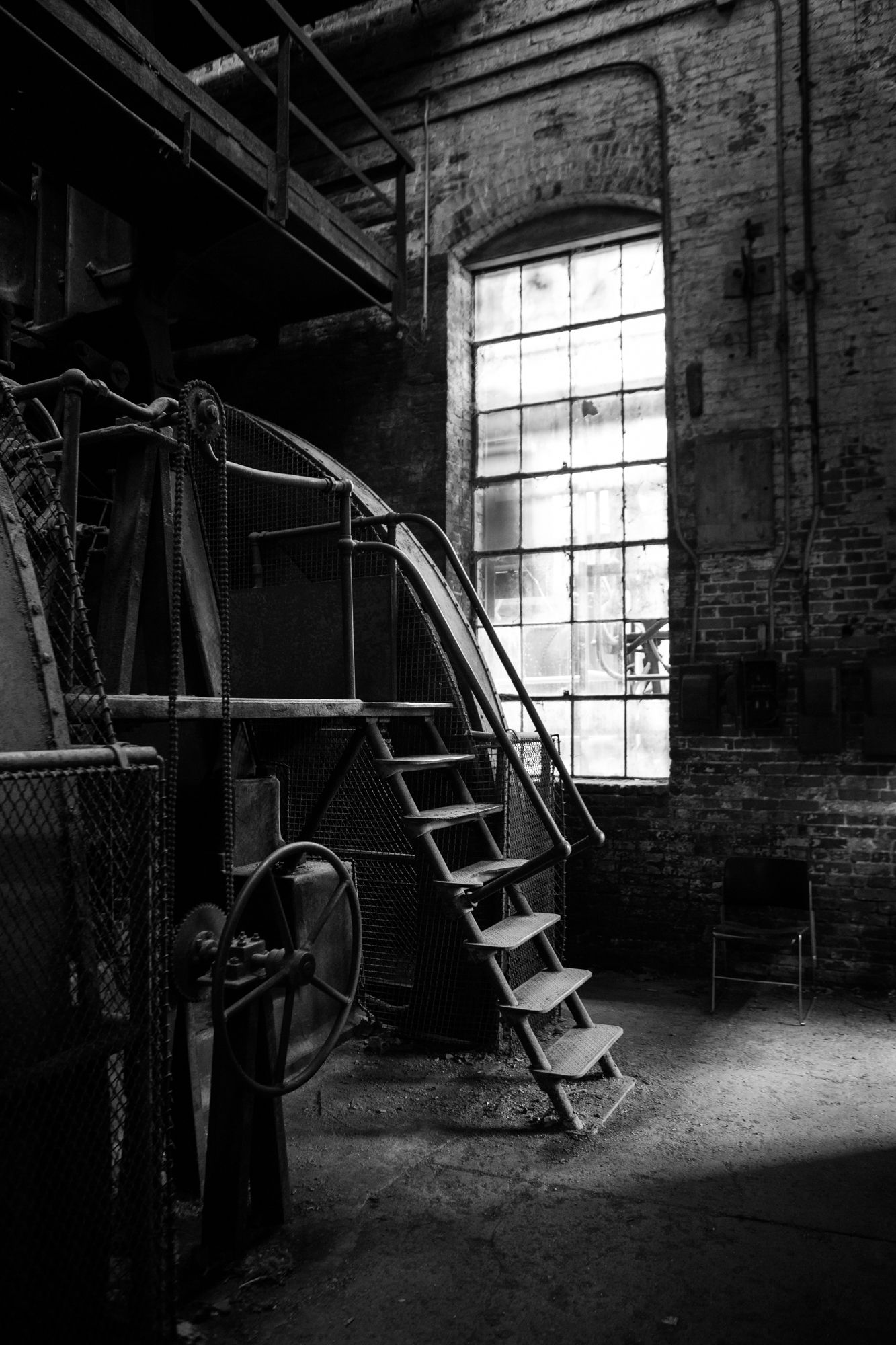 A black and white interior scene of a stairway at an iron mill