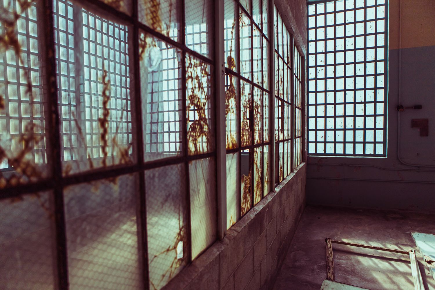 An interior view of broken windows in an abandoned building