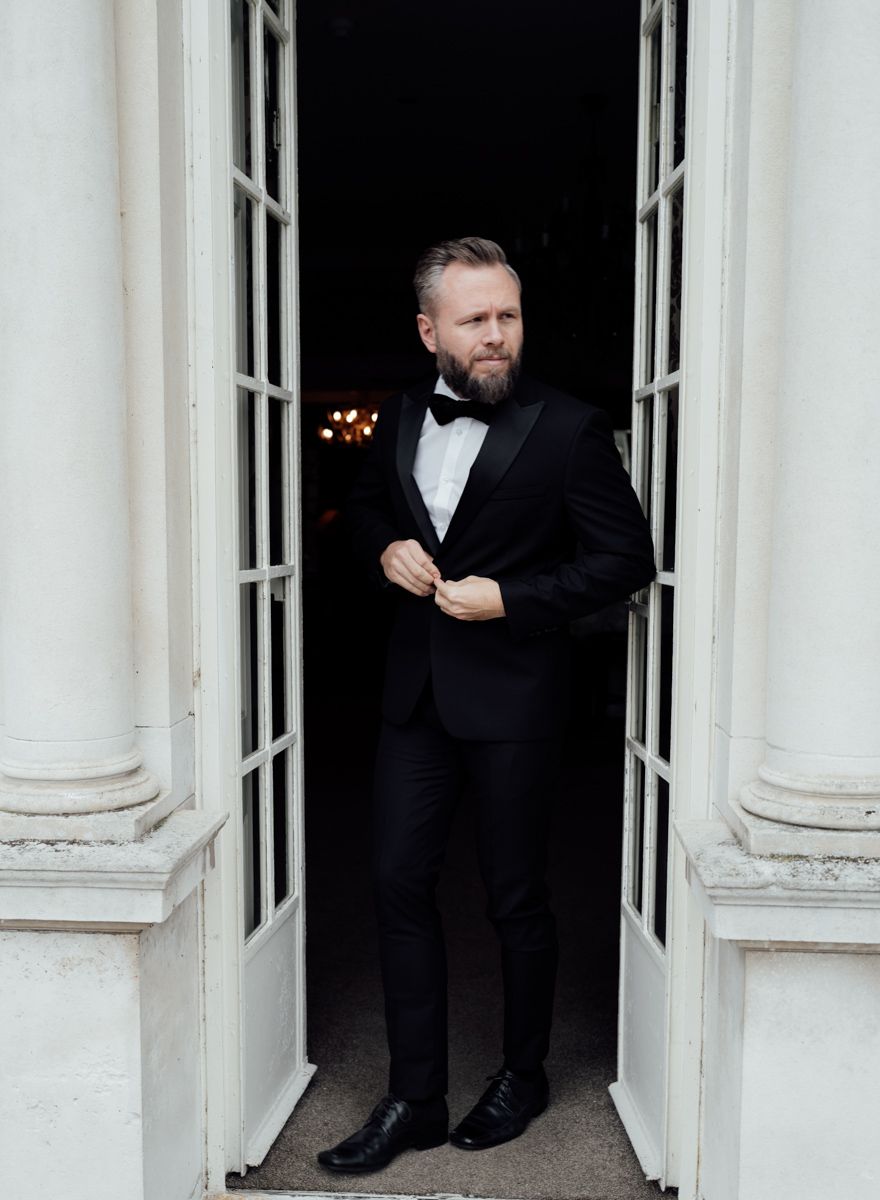 Groom portrait by the window at Eaves Hall, Lancashire  - editorial wedding photographer  in Lancashire