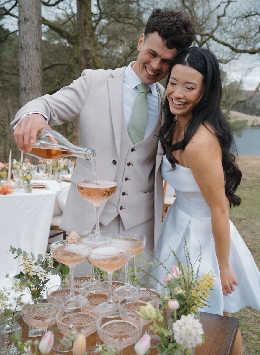 Bride and groom with champagne tower on a floral styled table