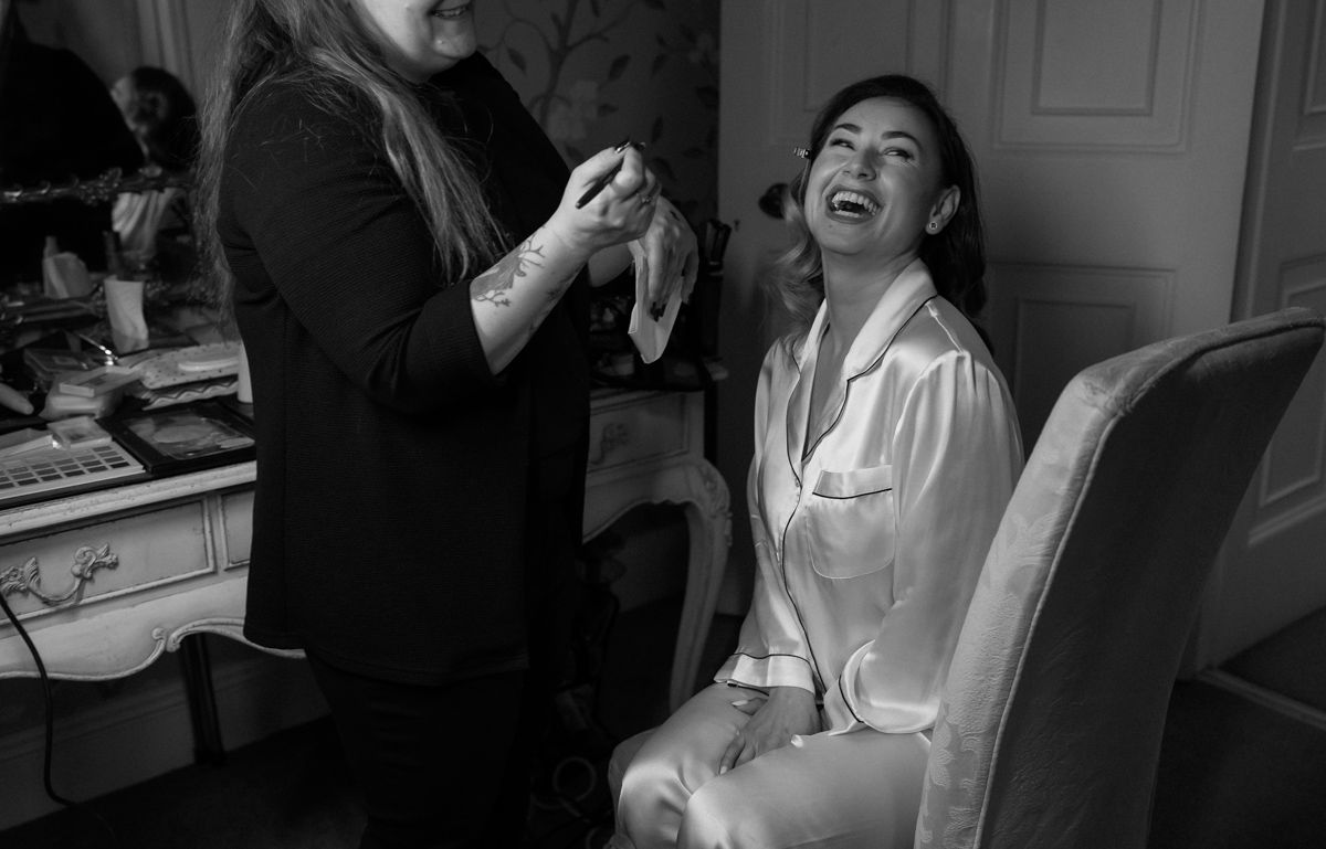 Bride getting ready on her wedding day, portrait by the window at Eaves Hall, Lancashire  - editorial wedding photographer  in Lancashire