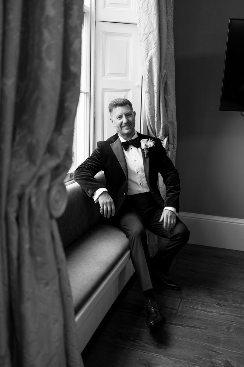 Groom portrait by the window at Bowcliffe Hall - editorial wedding photographer Yorkshire