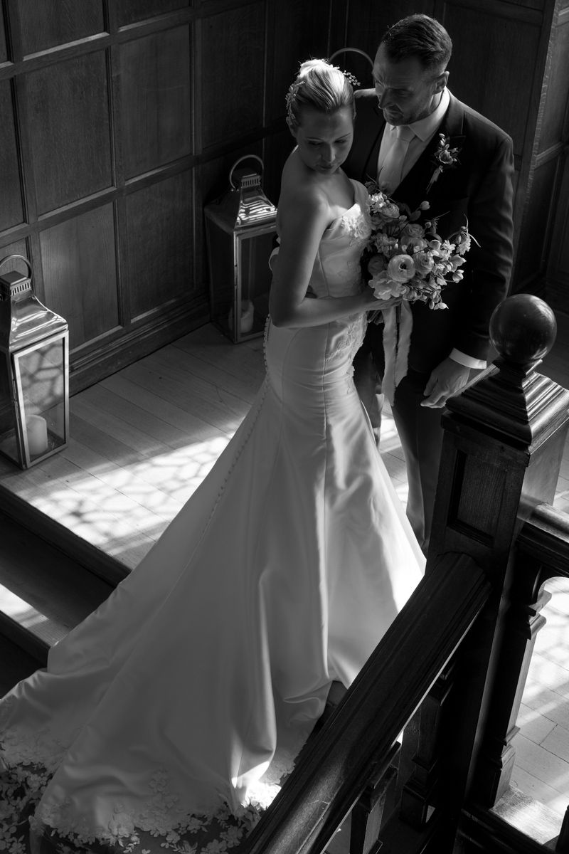 black and white groom and bride on the stairs in cheshire