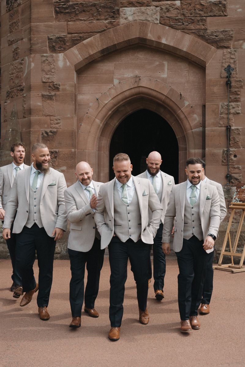 Groom and his friends walking the grounds of Peckforton Castle - candid emotional photographer Cheshire