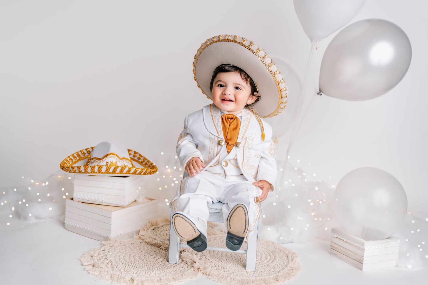 White studio setup with balloons and decorative elements for milestone photography.