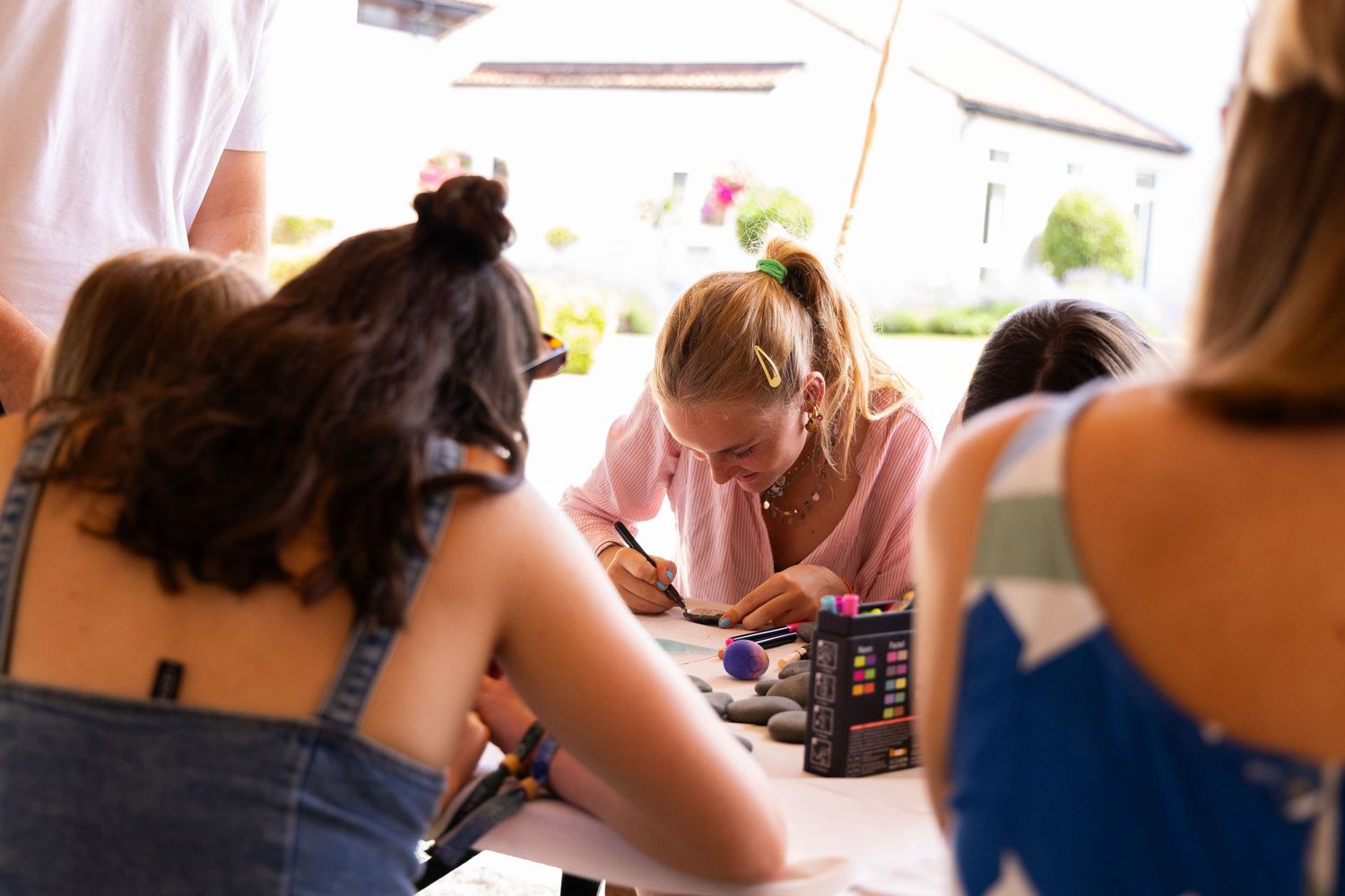 Study group gathered around a table during a casual learning session outdoors.