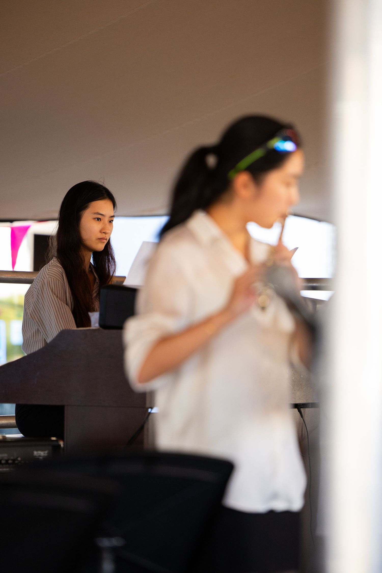 Office workers focused on computer screens in modern workplace setting.