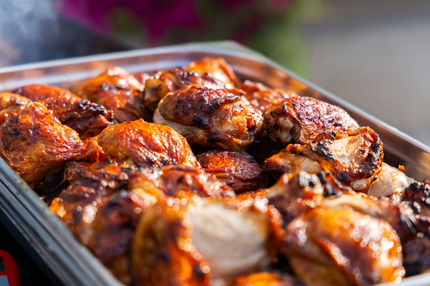 Close-up of grilled chicken pieces with caramelized glaze on a serving tray.