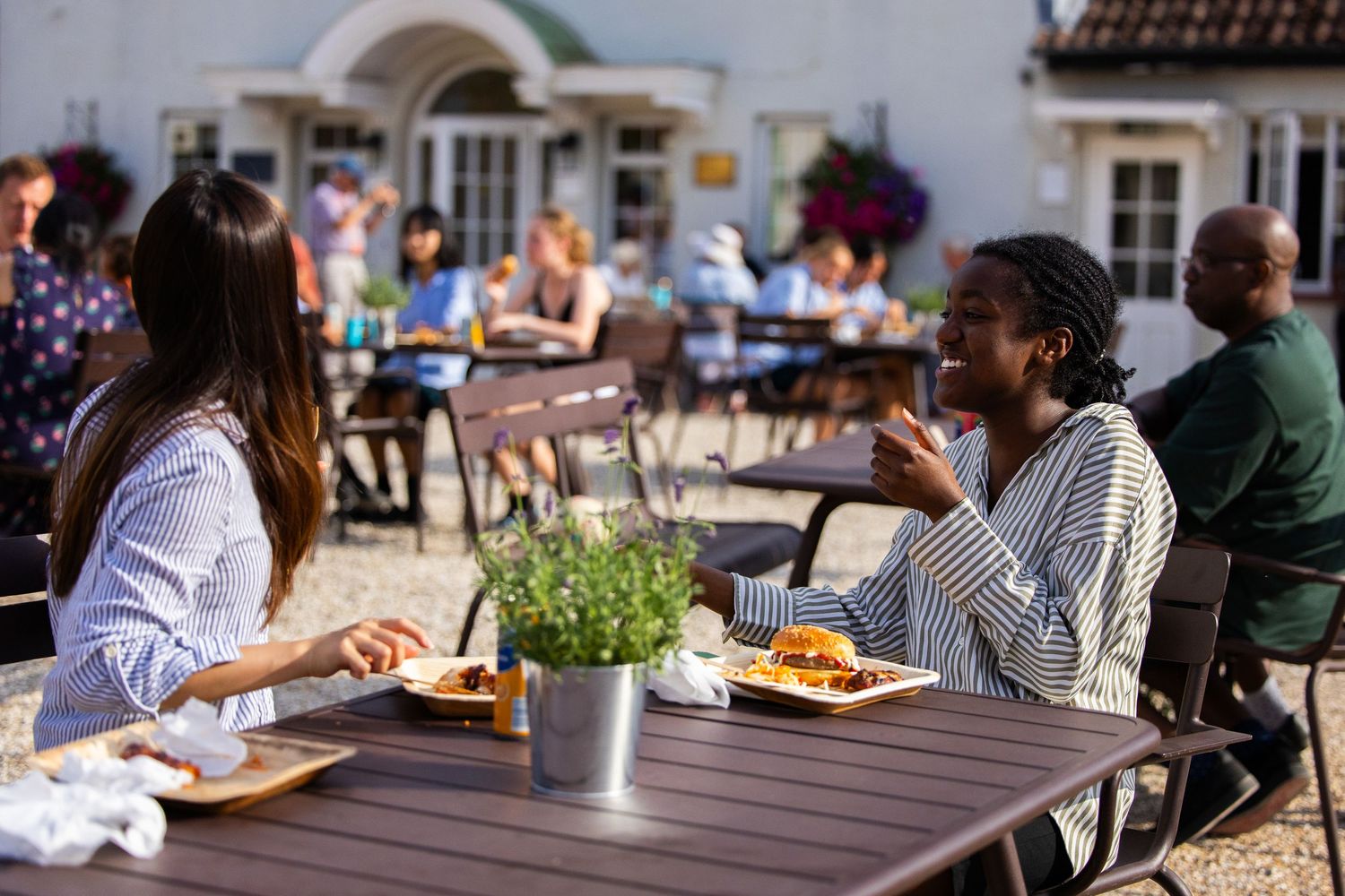 Guests enjoying an outdoor dining experience at restaurant tables with umbrellas.
