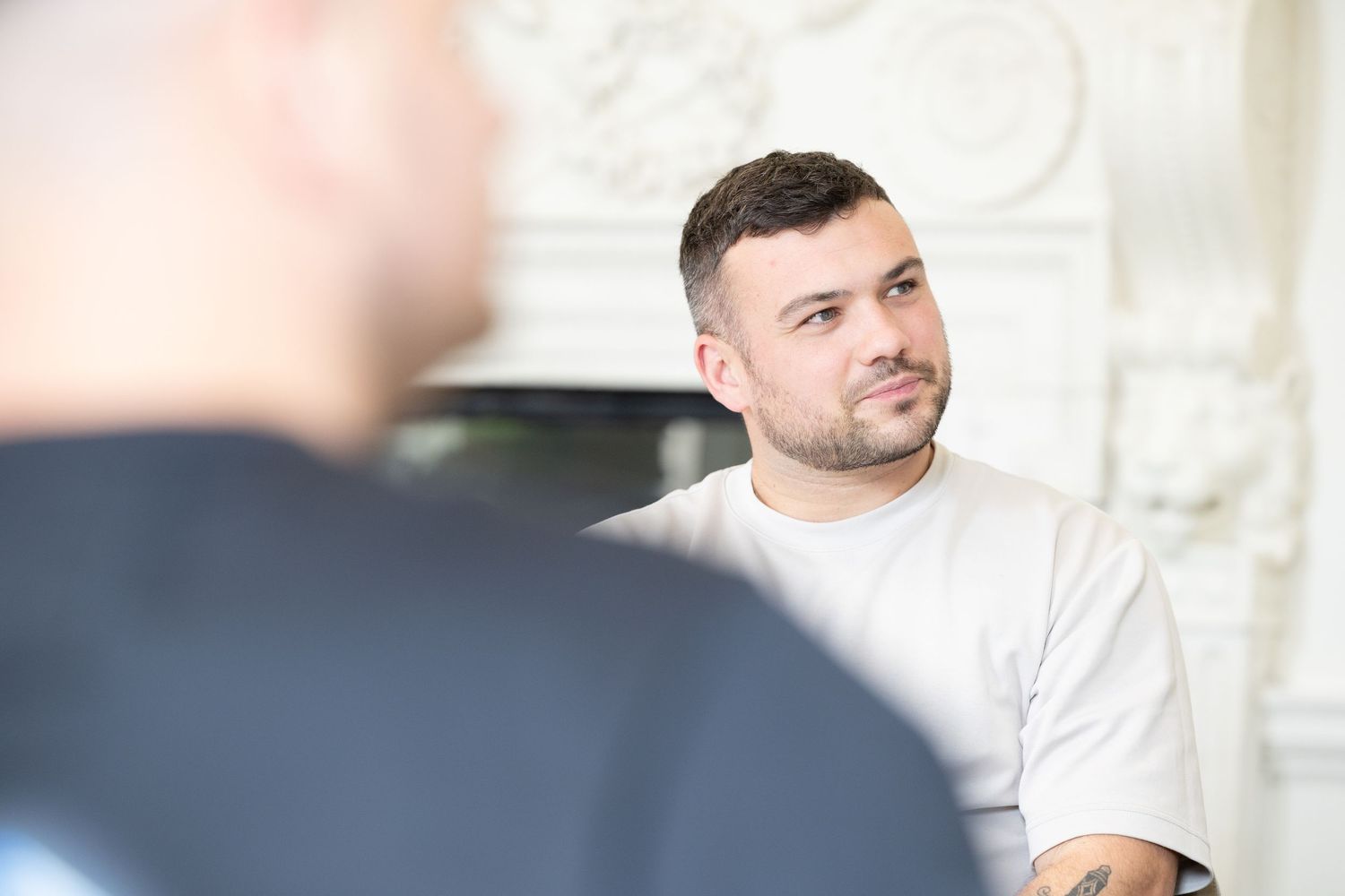 Two people engaged in a professional conversation in a bright office setting.