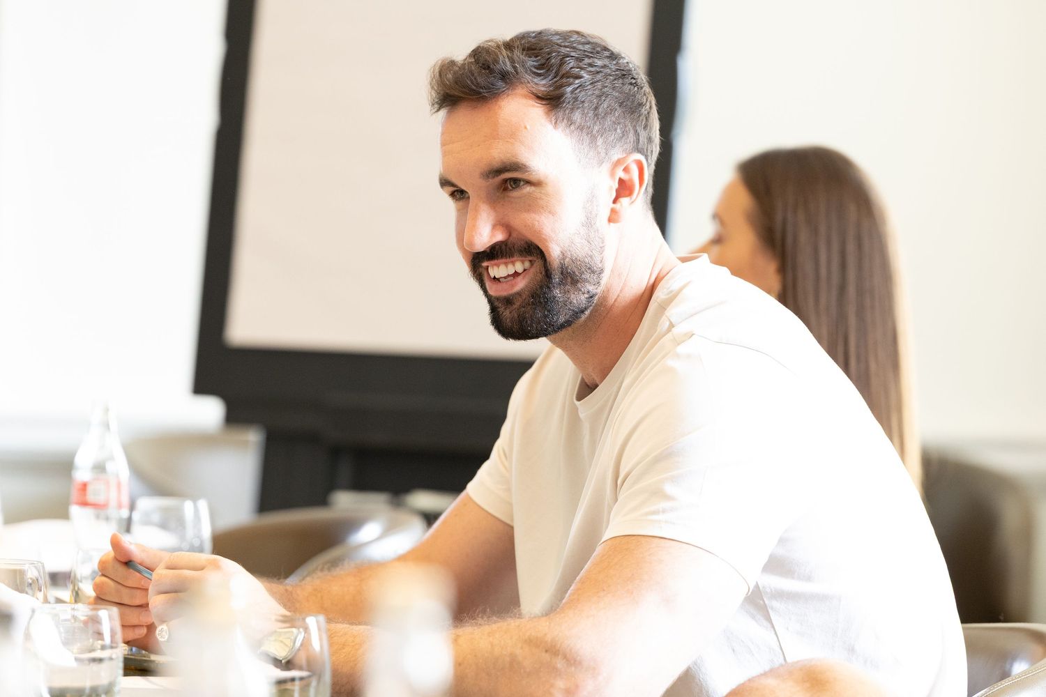 Cheerful person enjoying conversation at desk in modern office with coworkers.