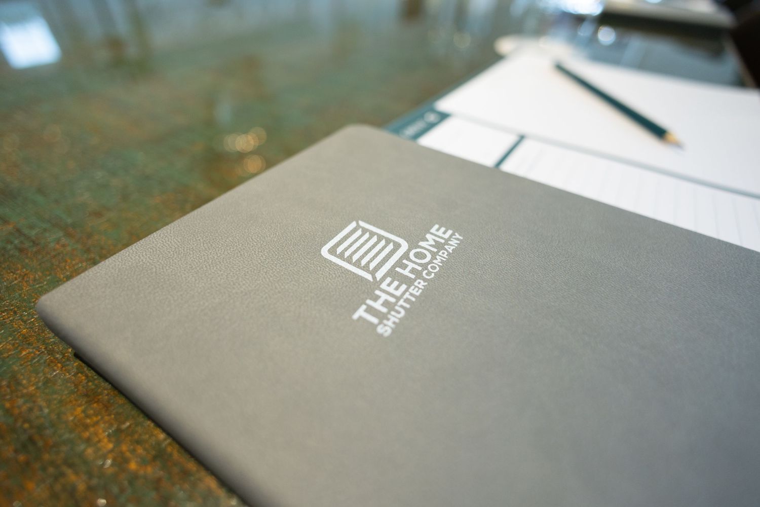 A gray branded ThinkStar notebook lying on a rustic wooden surface.