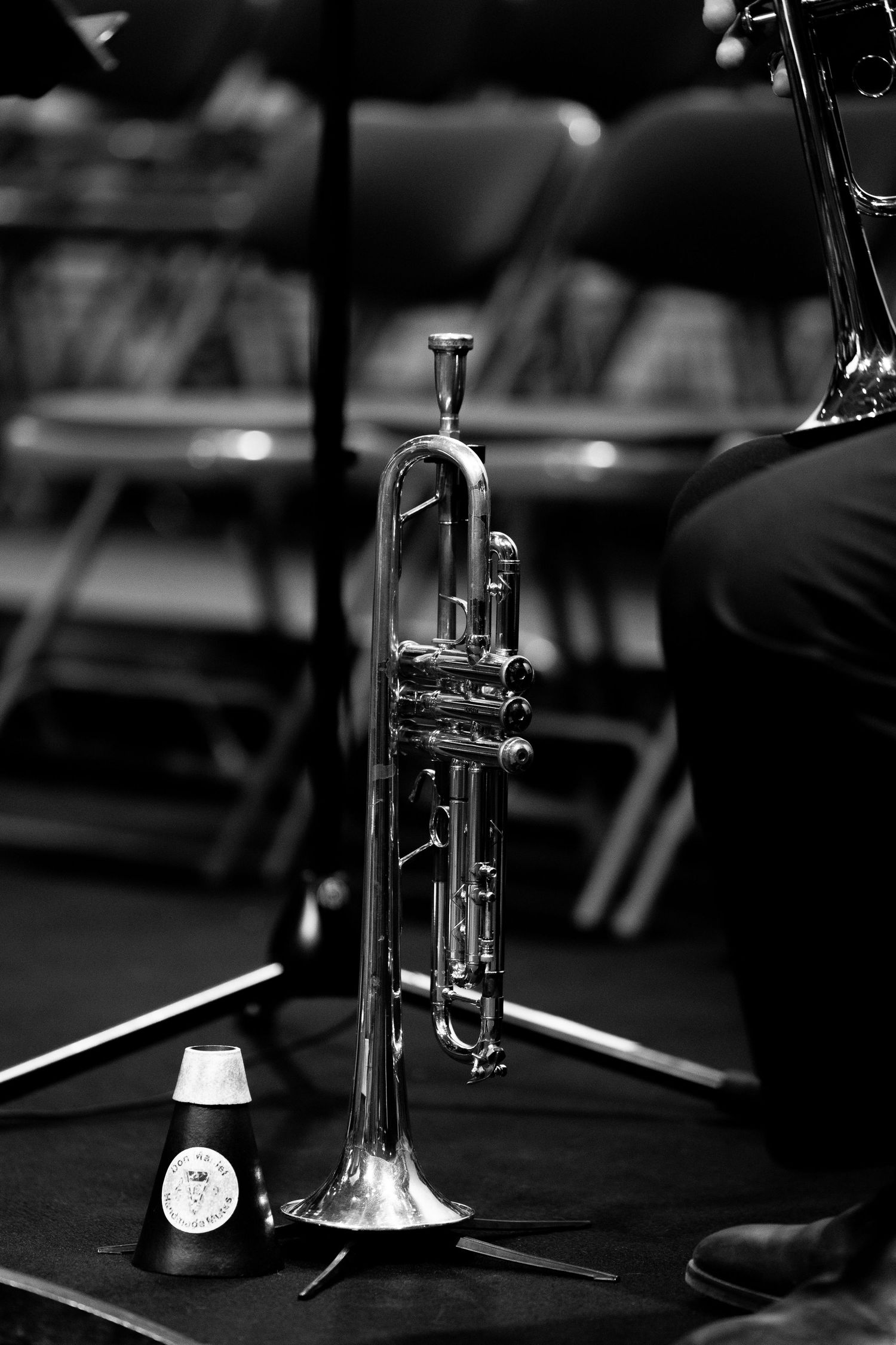 Multiple trumpet instruments arranged in a dark setting with selective lighting creating a dramatic musical ambiance.