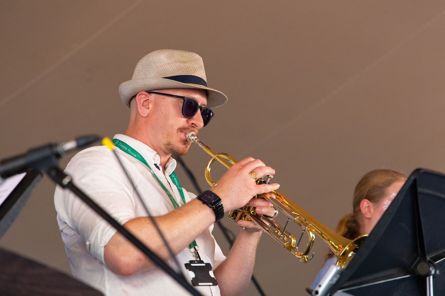 Musicians performing at an outdoor concert with brass instruments.