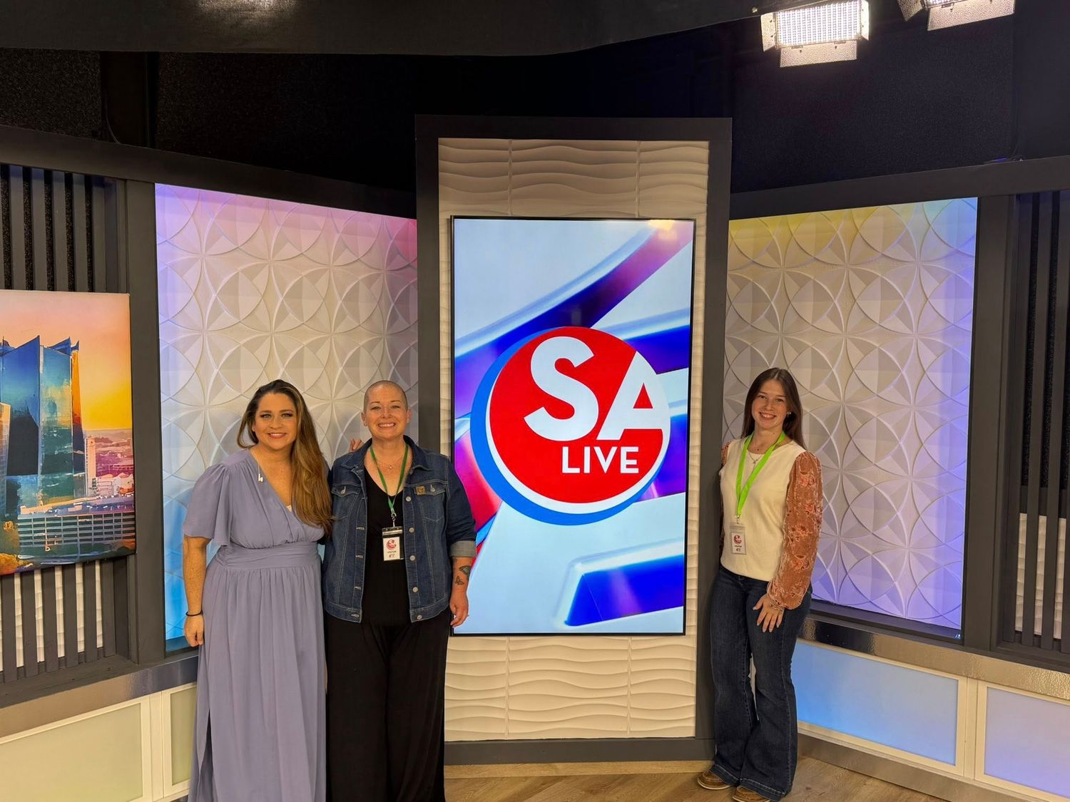 A television studio set with a large SA Life logo display screen and textured wall panels.