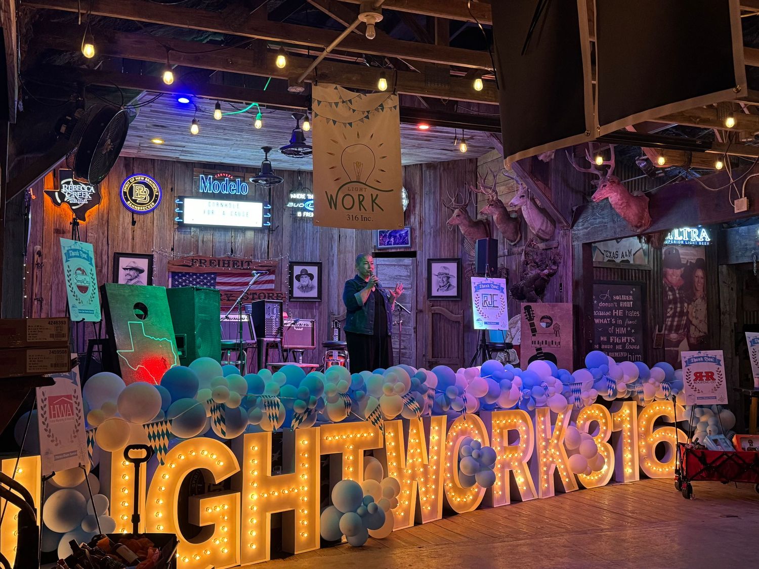 Nightworks316 marquee letter sign with balloons and string lights in a decorated event venue.