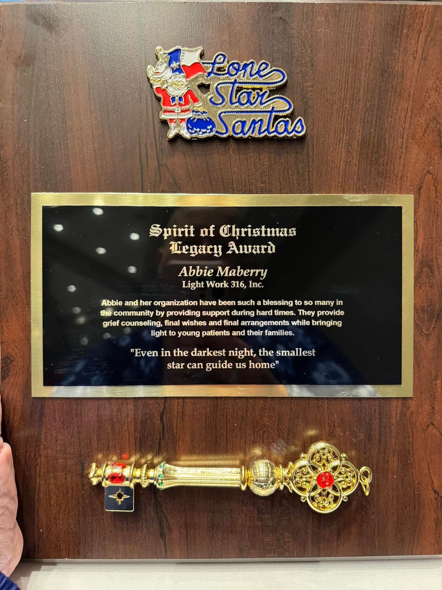 Decorative golden key ornaments and plaques mounted on dark wood paneling display text about Christmas spirit.