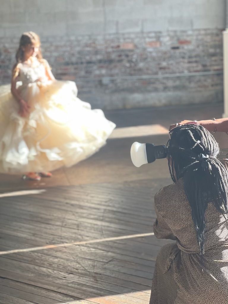 A photographer capturing a bride in a flowing dress during a photo session.