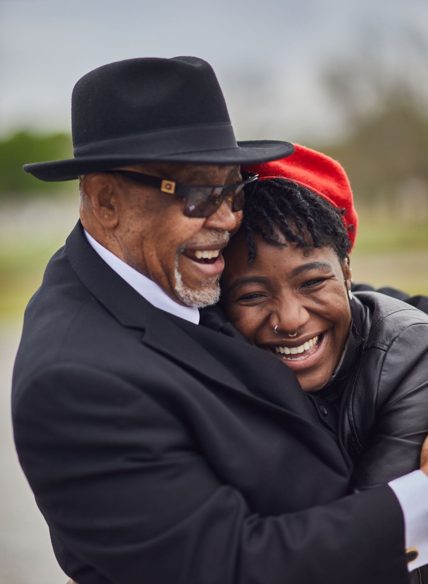 A joyful moment captured between two people sharing a warm embrace outdoors.
