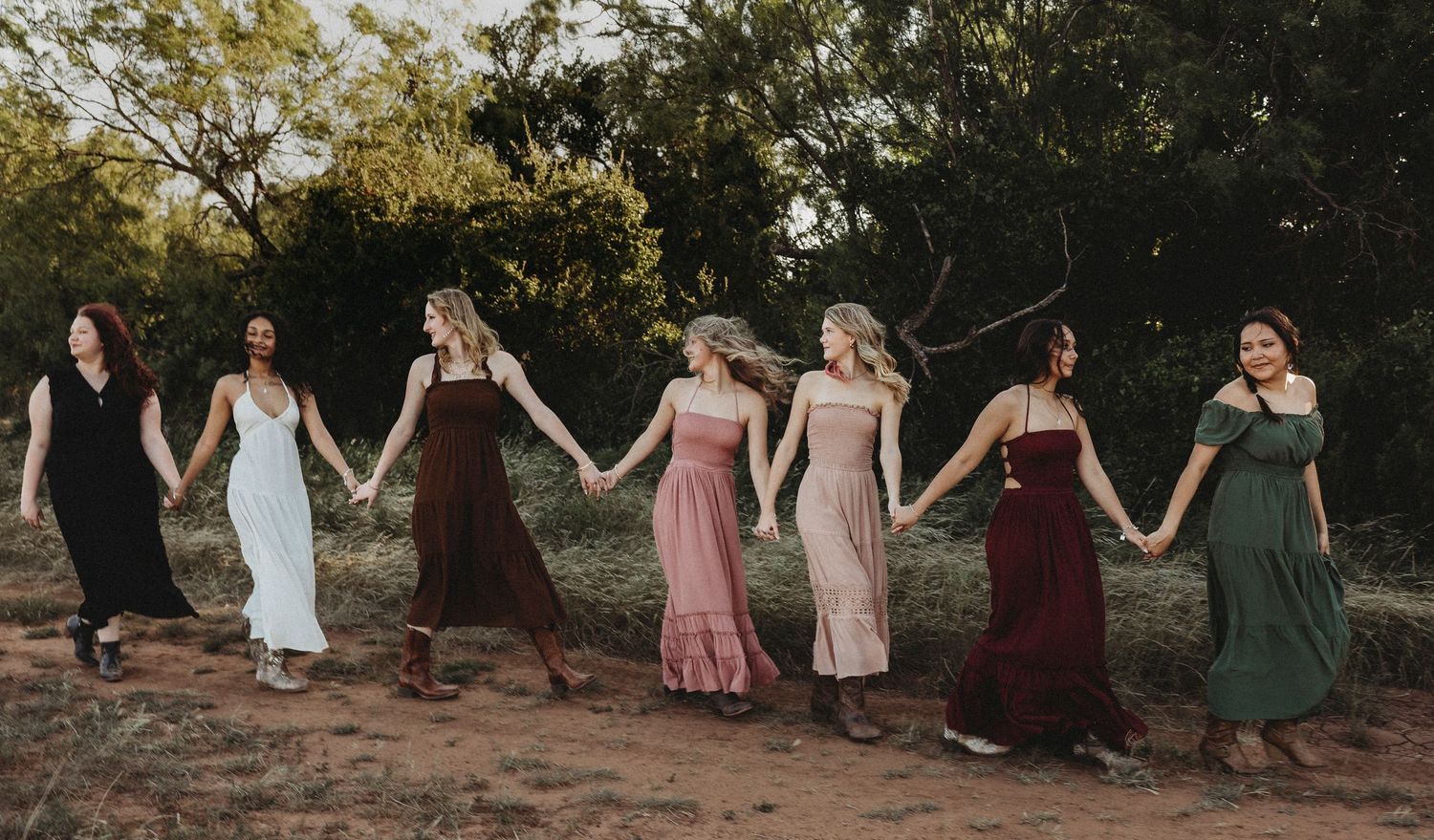 Class of 2027 Senior Rep Team walking hand in hand during a golden hour senior photography session in Abilene, Texas.