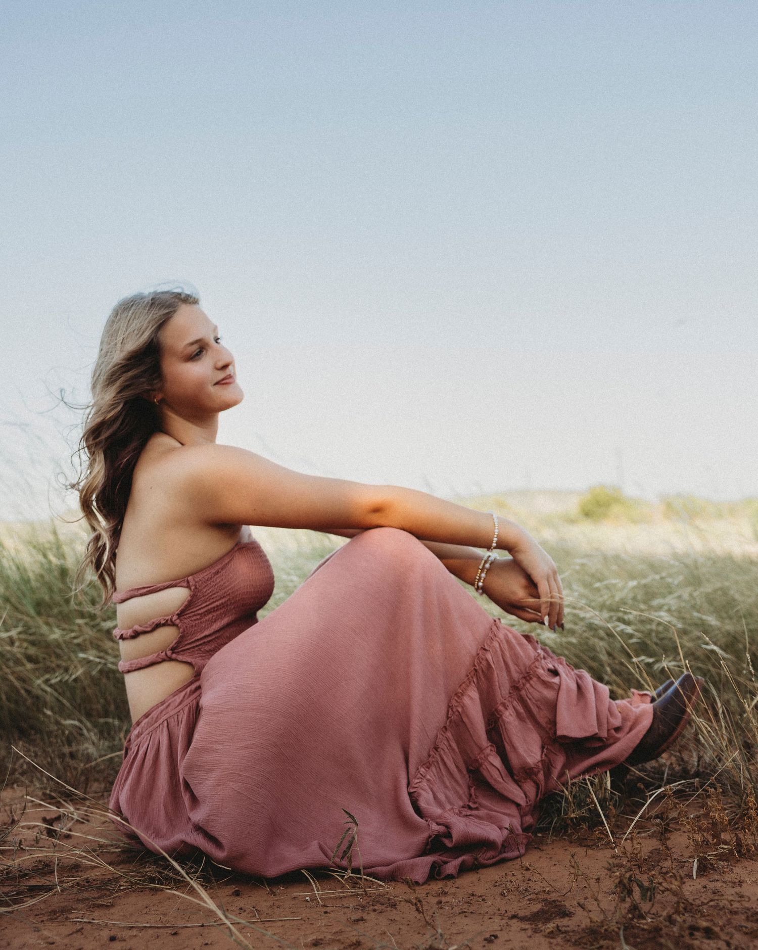 Golden hour senior portraits of a Class of 2027 senior in a flowing mauve dress during an outdoor senior photos session in Abilene, Texas.