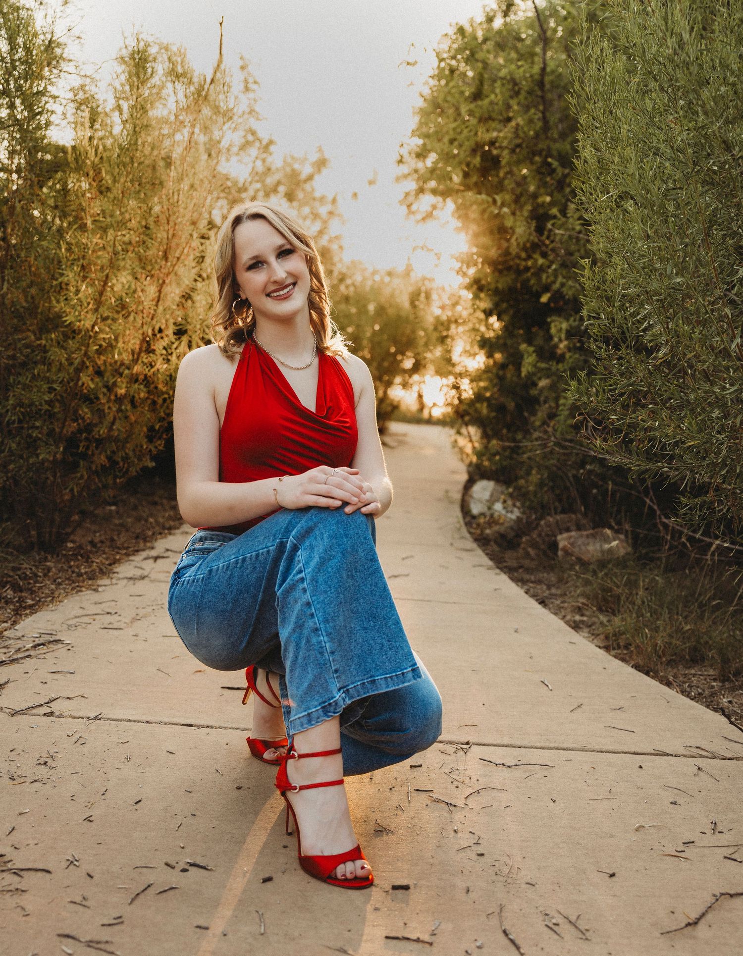 High school senior posing on a tree-lined pathway at sunset for a golden hour senior photography session in Abilene, Texas.