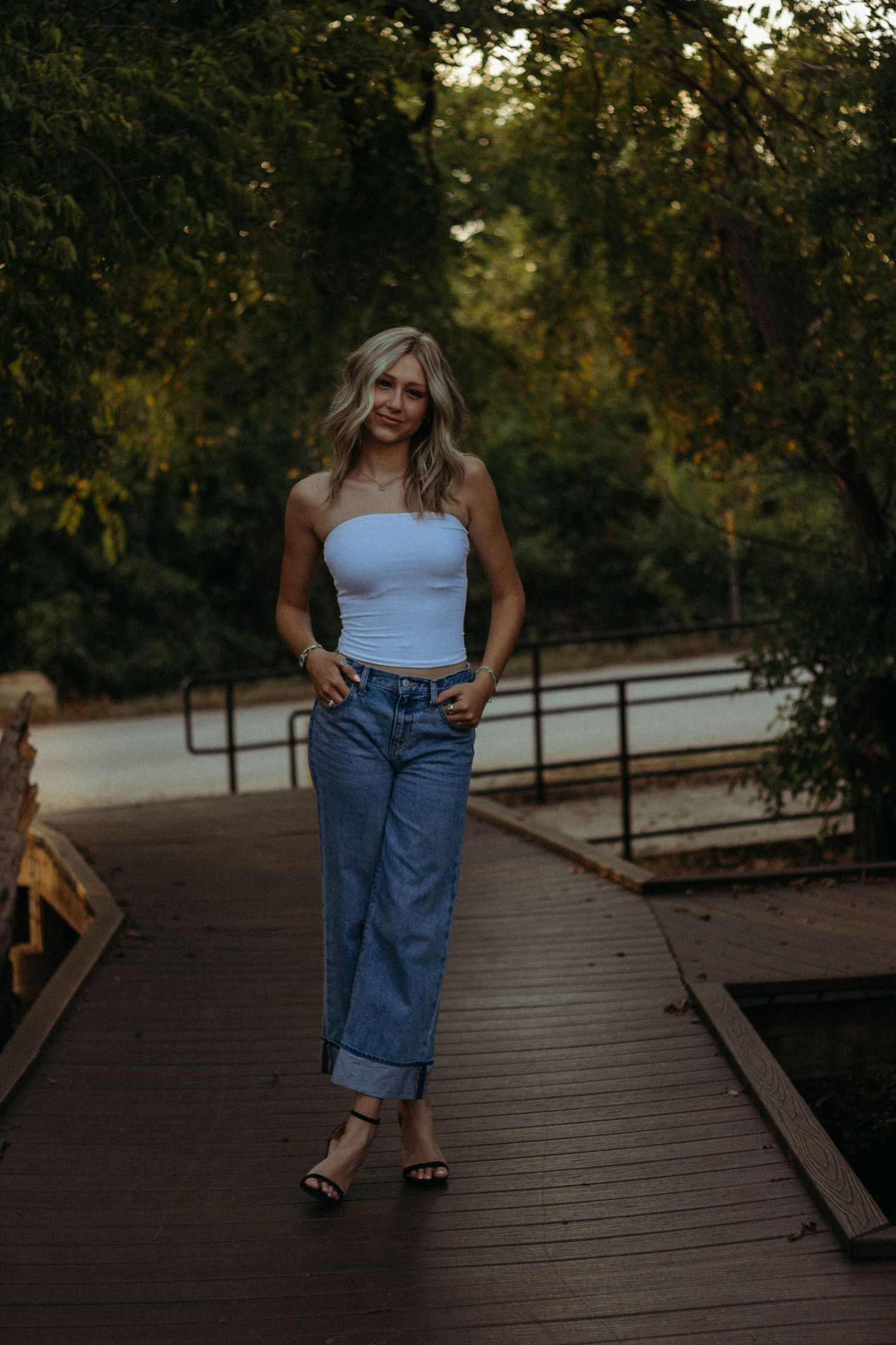 Abilene TX high school senior portrait session on a wooden bridge with relaxed, confident posing