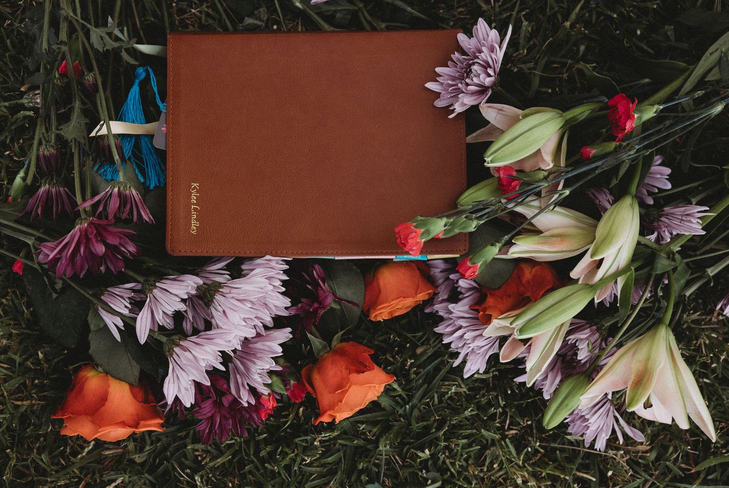 Personalized Bible surrounded by fresh flowers during a Wylie High School Class of 2027 senior portrait session in Abilene, Texas.
