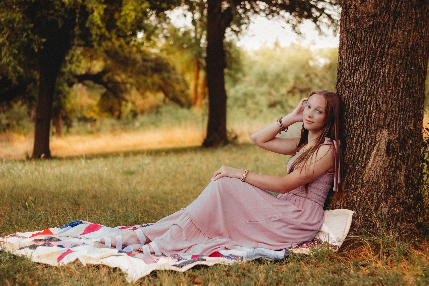 Lifestyle senior portrait session in Abilene TX featuring a high school senior relaxing under a tree in a natural outdoor setting